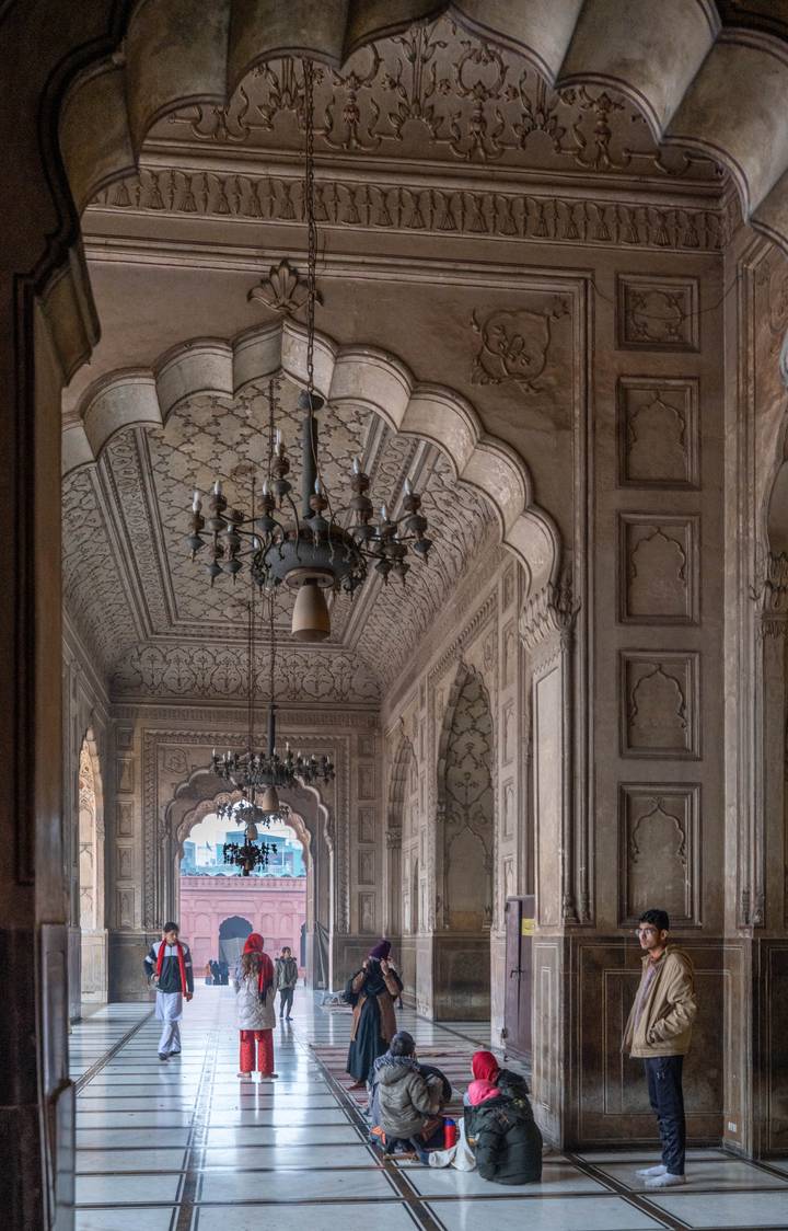 Intricate carved ceiling and chandeliers inside a historic Mughal mosque.