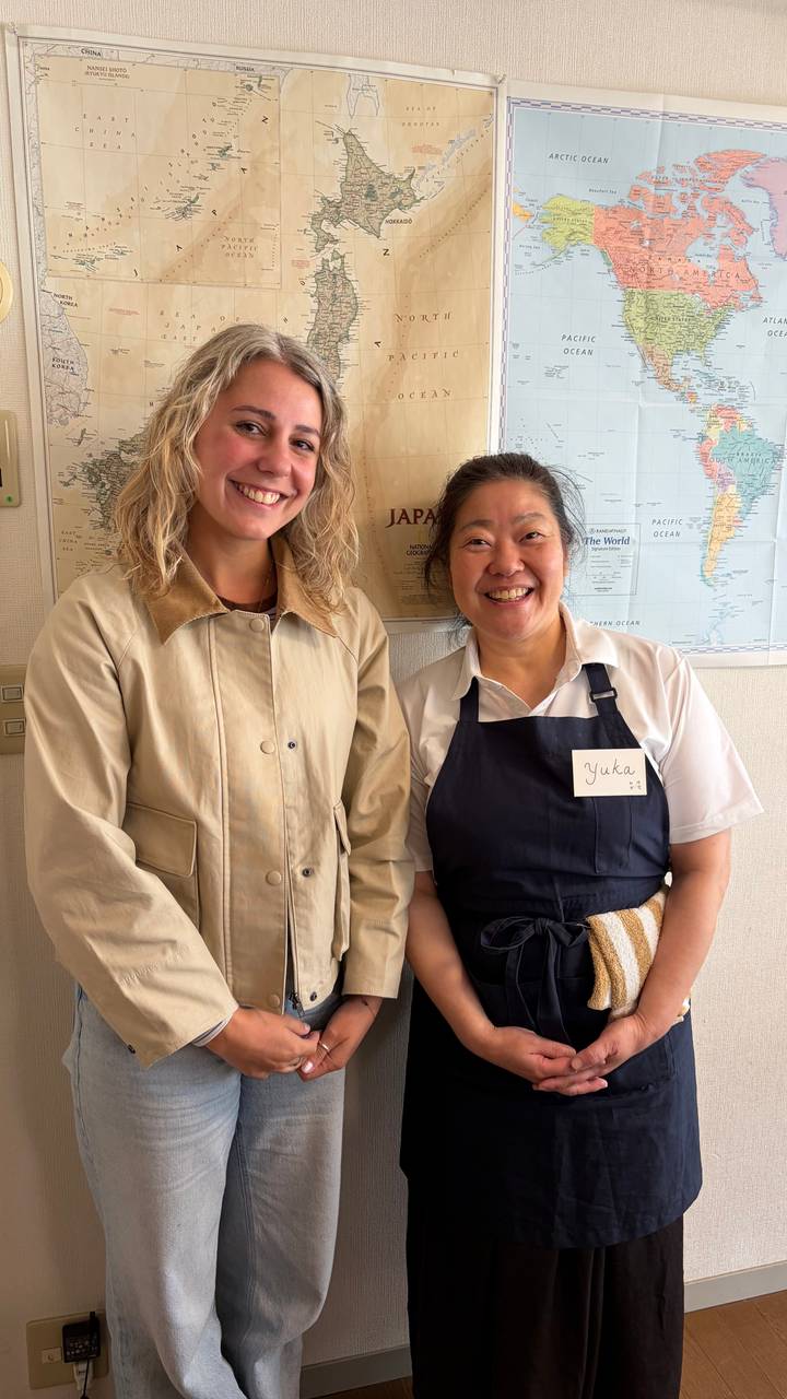 Traveller posing with friendly local hostess inside classroom-style setting