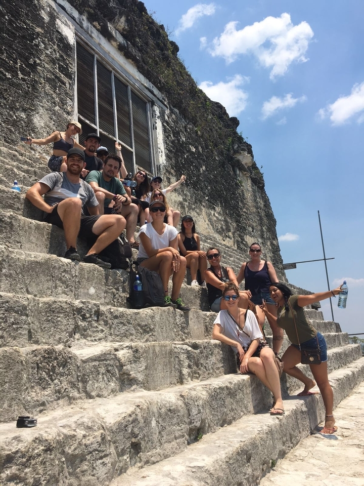 Groupe de personnes assises sur d'anciennes marches en pierre.