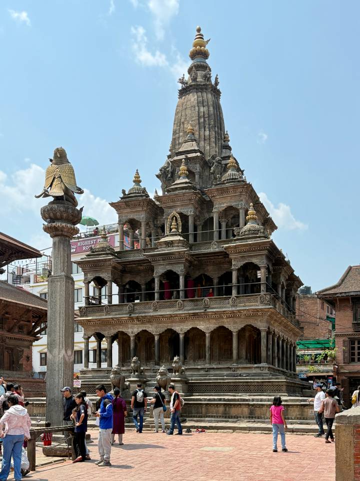 Elegant stone temple with intricate carvings and golden finials in Patan Durbar Square