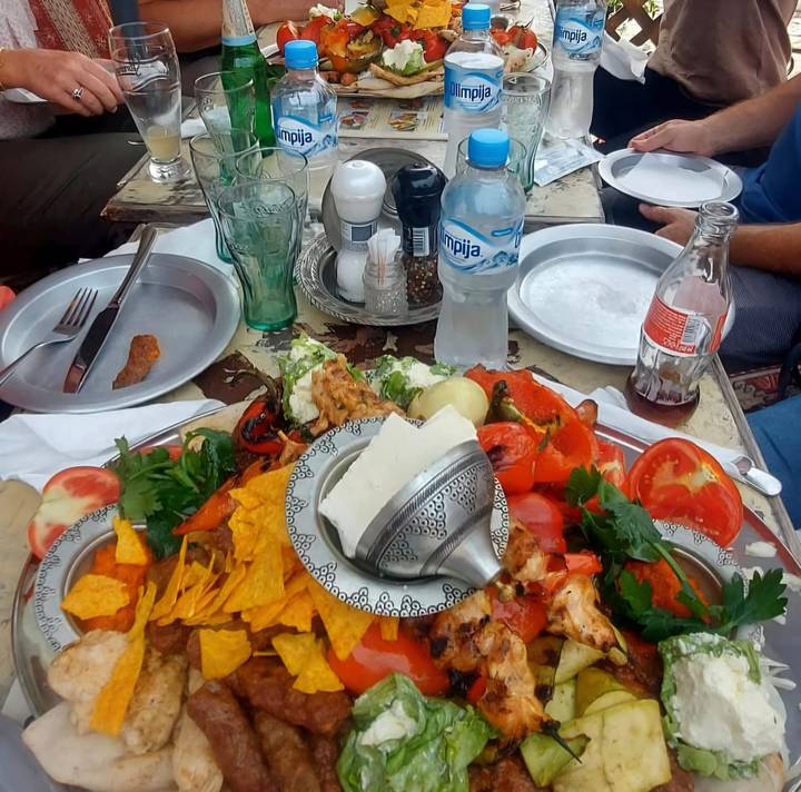 Close-up of assorted food platter including cheese, vegetables and nachos on a table.