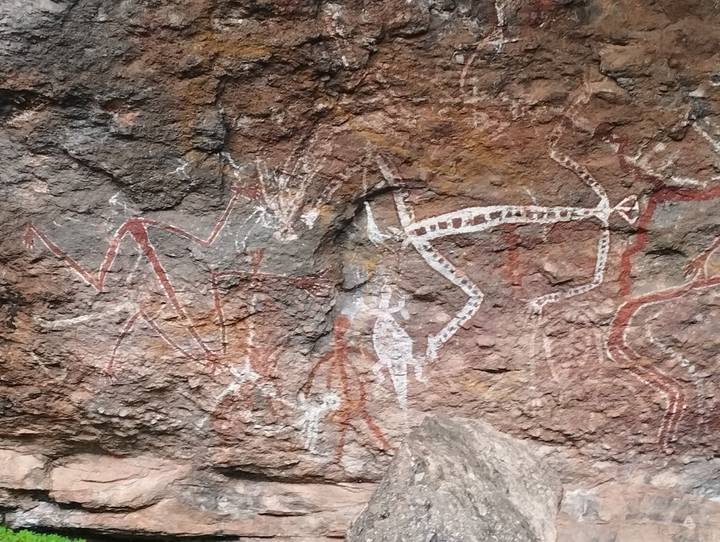 Ancient Aboriginal rock art depicting animals and human figures painted on a cave wall
