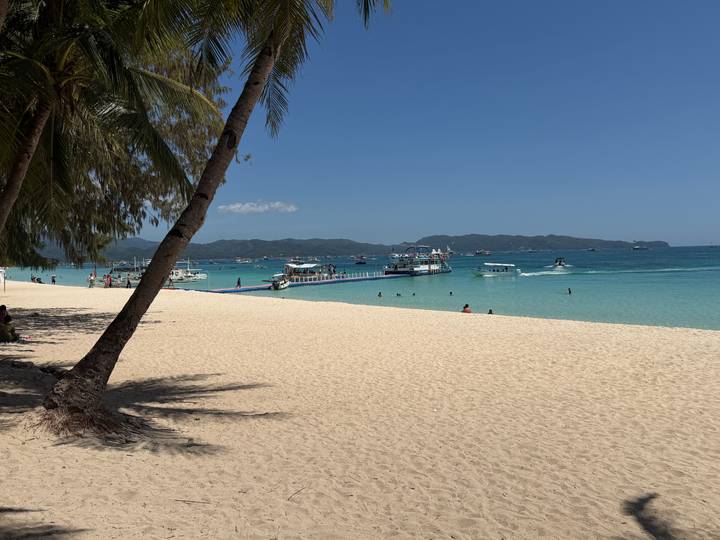 Powder-white Boracay beach with turquoise water, boats and distant islands