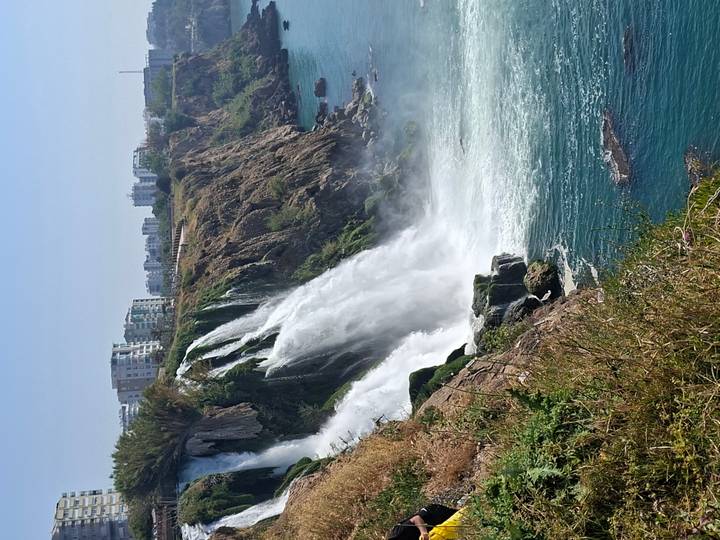 Powerful coastal waterfall plunging from city cliffs into turquoise Mediterranean