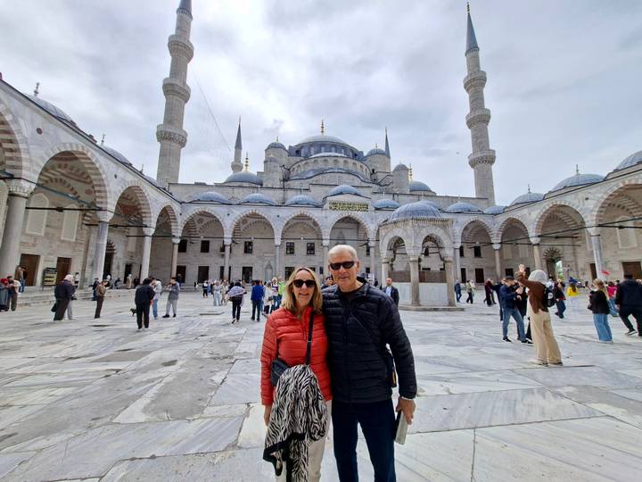 Couple posing in the expansive marble courtyard of the Blue Mosque in Istanbul