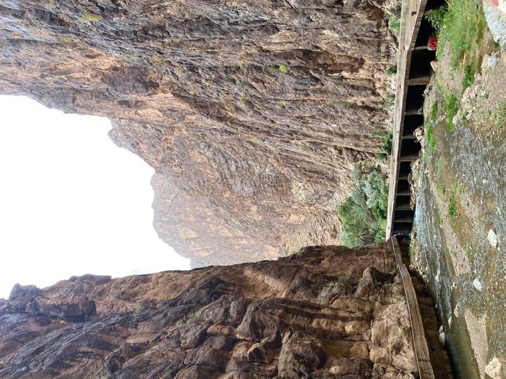 Narrow river flows through towering, rugged canyon walls in the Todra Gorge.
