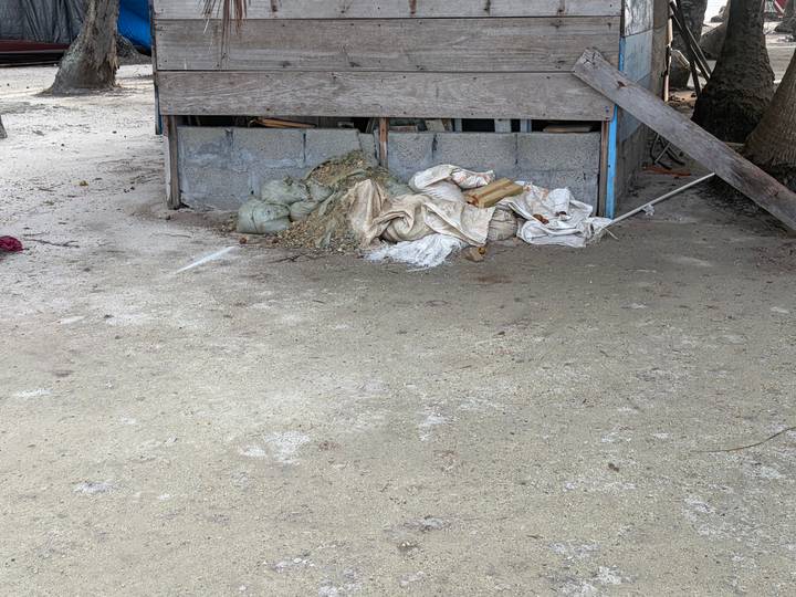 Construction debris and sand piled beneath a raised wooden structure