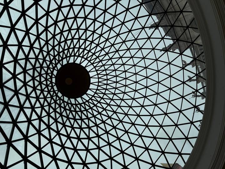 Interior view of a patterned glass dome ceiling with a geometric lattice and central oculus.