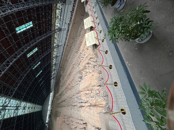 Vast hangar containing rows of excavated Terracotta Warriors and horses behind protective barriers in Xi’an.