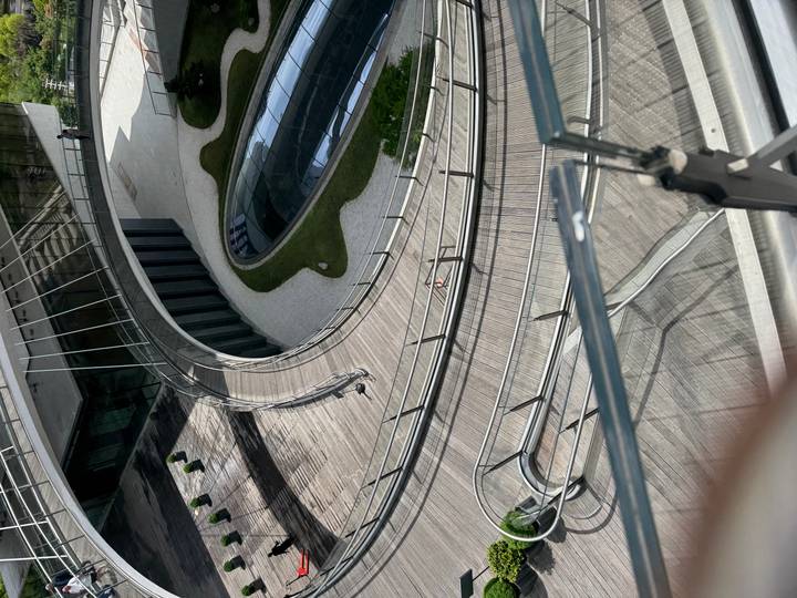 Modern spiral ramp and glass roof courtyard of a contemporary building viewed from above.