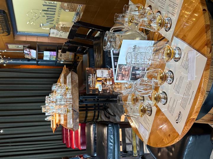 Tables set with multiple whiskey tasting glasses await visitors inside a craft distillery.
