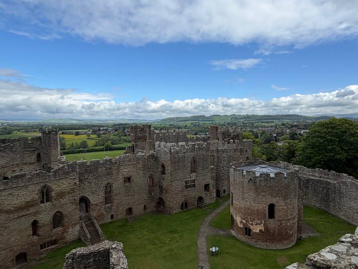 Aerial-style view of Ludlow Castle ruins overlooking green English countryside