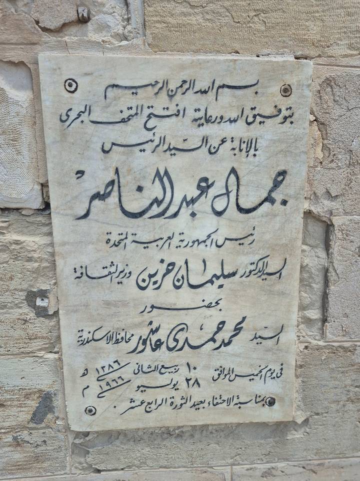 Close-up of Arabic inscription plaque carved on aged marble.