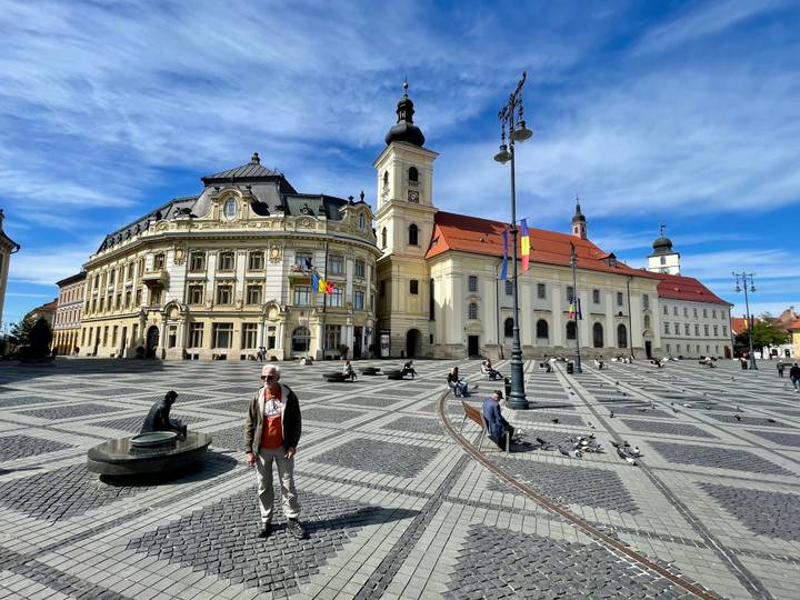 The grand baroque buildings of Sibiu’s Great Square stand over patterned cobblestones and strolling visitors.