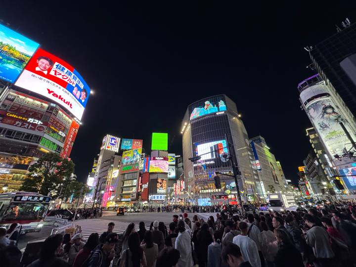 Night view of bustling Shibuya Crossing with bright neon billboards and crowds