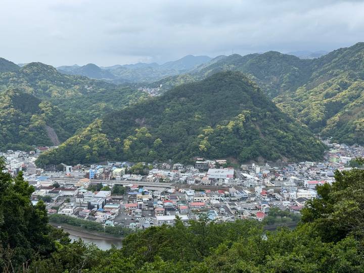 Elevated panorama of Japanese town nestled among green mountains