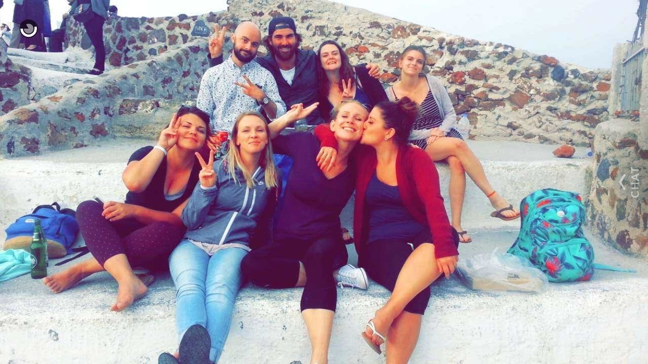 Groupe de personnes assises sur des marches en plein air en train de s'amuser.