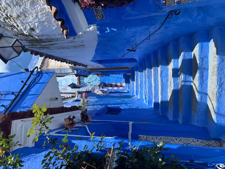 Bright blue stairway alley with white accents and hanging lanterns in Chefchaouen’s medina.