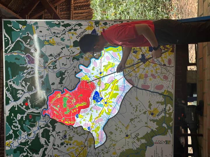 Guide pointing at a large colourful planning map mounted on a board.