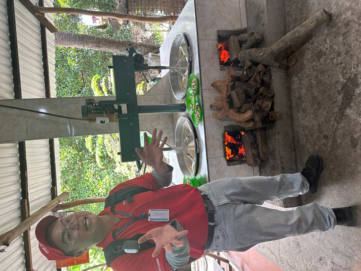 Guide explains a traditional stove with green rice-cake molds over wood fires at a workshop.