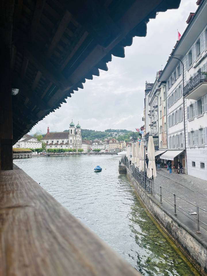 Picturesque waterfront of Lucerne with Chapel Bridge roof, church towers and lakeside cafes