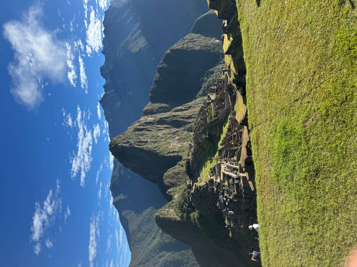 Iconic panoramic view of Machu Picchu ruins under a clear blue sky with surrounding Andes