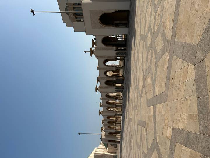 Expansive marble courtyard and elegant arches of Hassan II Mosque bathed in morning light.