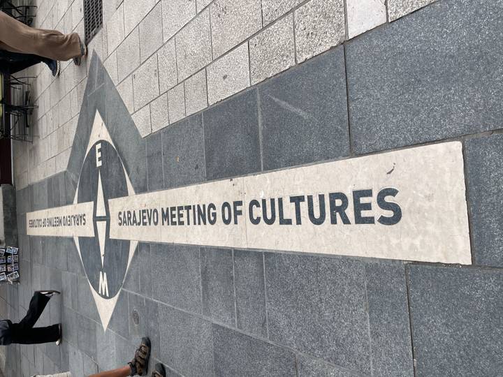 "Sarajevo Meeting of Cultures" line set into city pavement dividing architectural styles.