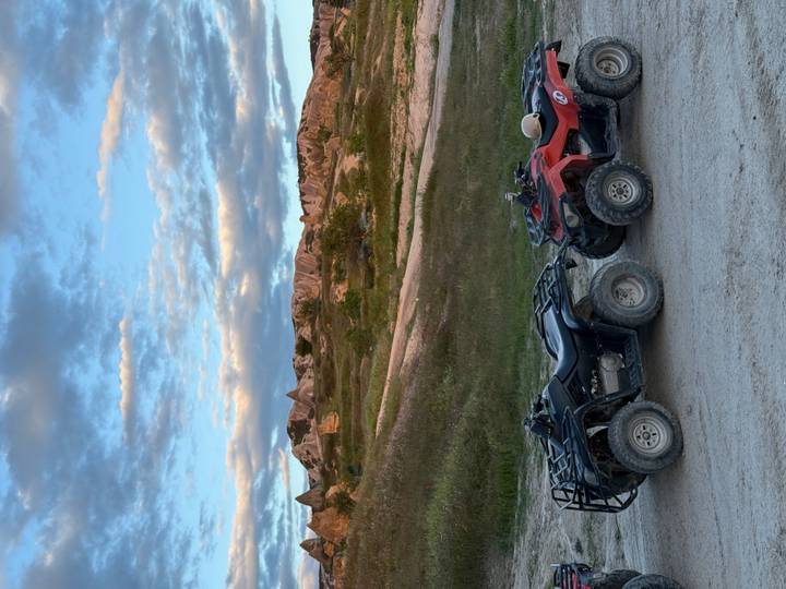 Two quad bikes parked on a dirt road with Cappadocia’s fairy-chimney landscape behind.