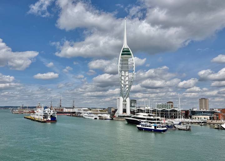 Panoramic harbour scene featuring the Spinnaker Tower, boats and turquoise water in Portsmouth.