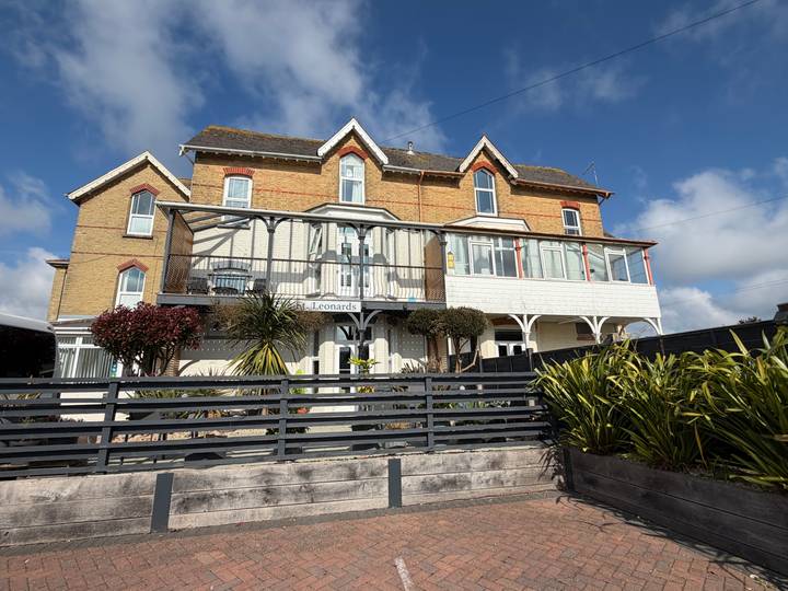 Sunny exterior of The St Leonards guesthouse, an attractive brick and timber building.