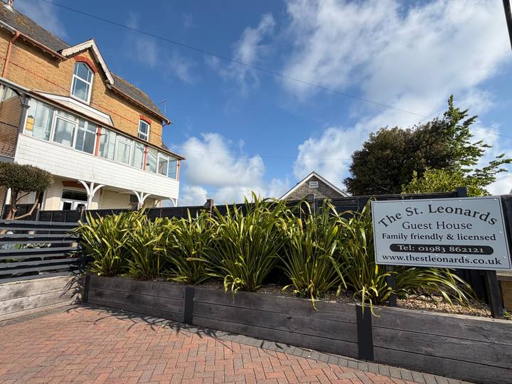 Signboard and planter outside The St Leonards Guest House on a sunny morning.
