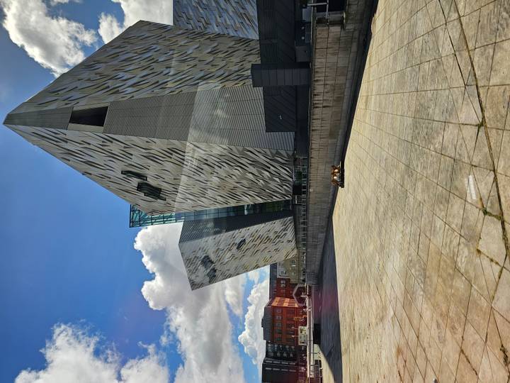 Modern Titanic Belfast museum with angular silver façades under bright sky.