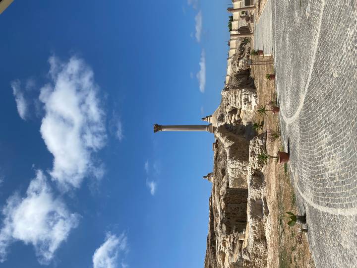 Clear view of Pompey’s Pillar standing amid scattered ruins under deep blue sky
