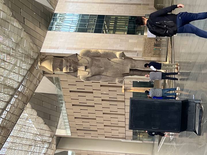 Visitors admire the colossal statue of Pharaoh Ramses II in the bright entrance hall of the Grand Egyptian Museum.