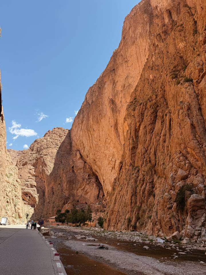 Sheer red rock walls of a narrow gorge rising against a blue sky.
