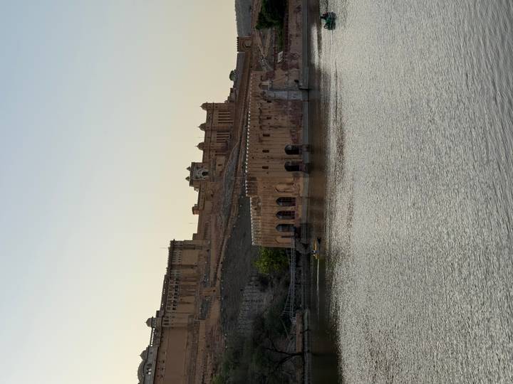 Distant view of Amber Fort and Jaigarh structures overlooking Maota Lake in the soft evening haze.