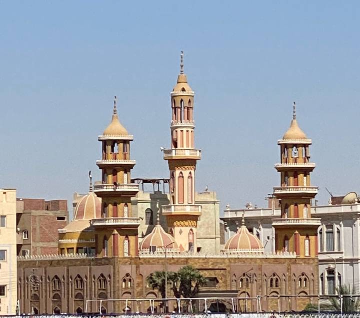 Close-up view of ornate mosque minarets and domes against a clear blue Cairo sky