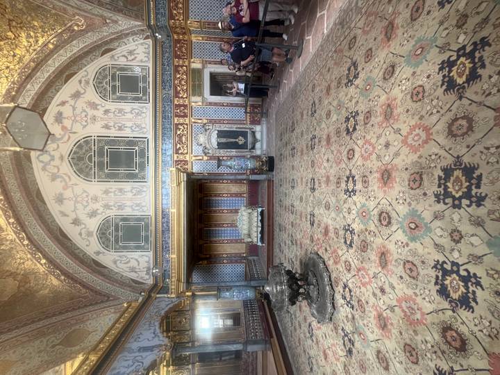 Ornate Sultan’s chamber with patterned carpets and tiled walls inside Topkapi Palace.