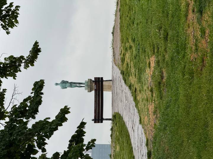 The Pobednik statue stands beyond a park bench on an overcast day in Belgrade's Kalemegdan Fortress.
