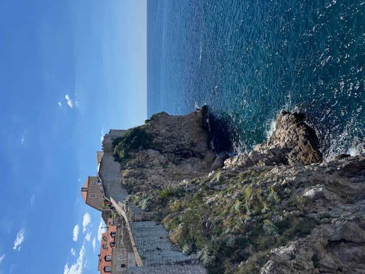 Steep limestone cliffs drop to deep blue Adriatic waters beneath Dubrovnik’s ancient city walls.