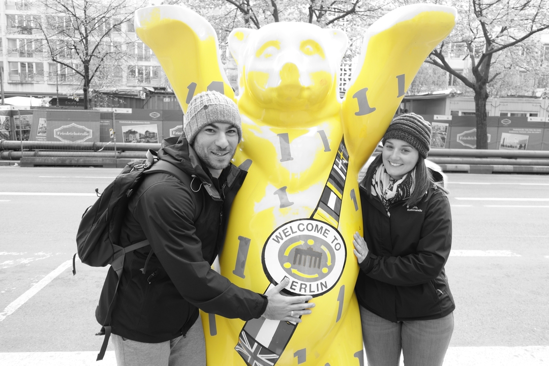 Touristes posant avec une statue d'ours jaune à Berlin.