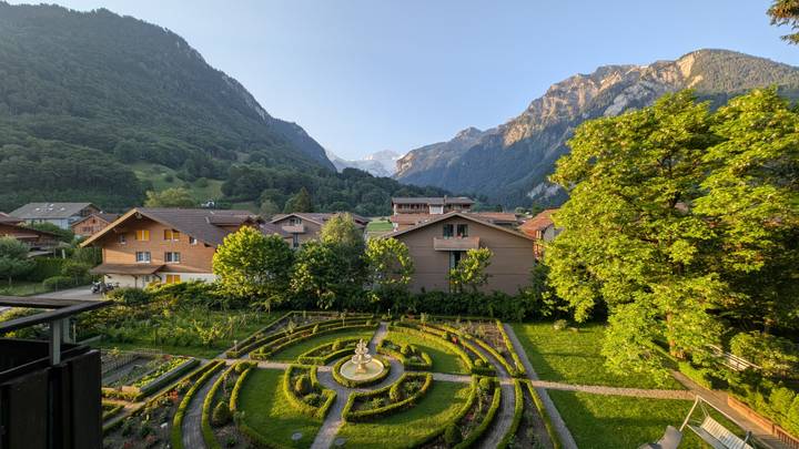 Well-kept garden and alpine village framed by towering peaks and glacier