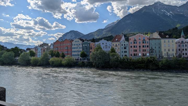 Colorful riverside facades of Innsbruck mirrored in swift flowing river