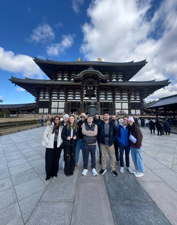 Tour group posing in front of the vast wooden Great Buddha Hall of Todai-ji Temple.