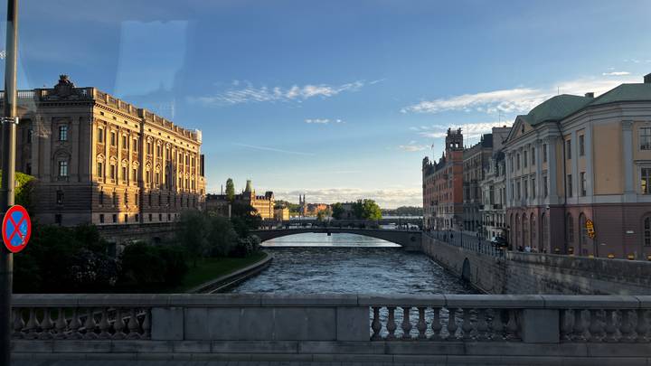 Stockholm’s Royal Palace and Parliament buildings overlooking a tranquil canal and bridge.