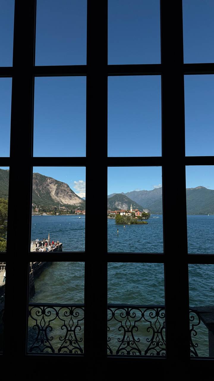 Lake and mountain scenery framed by dark window panes creating a cross pattern.