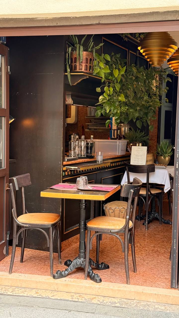 Cozy corner of a small restaurant with wooden tables, pink placemats and vintage décor.