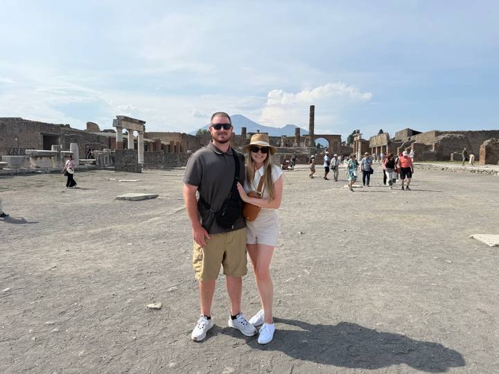 Couple in front of Pompeii ruins with Mount Vesuvius towering in the background