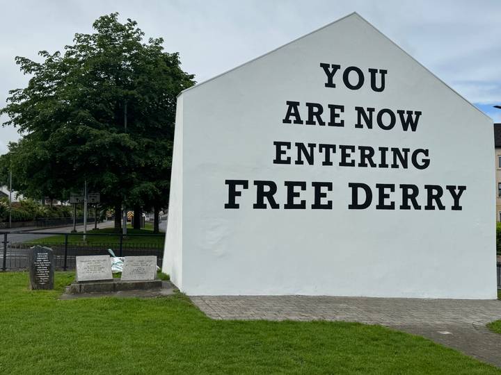 Famous white gable with bold black lettering reading 'YOU ARE NOW ENTERING FREE DERRY'